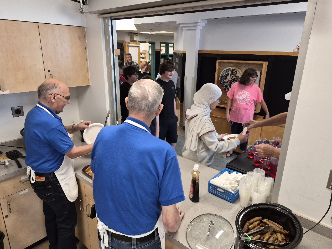 Serving pancakes and juice to students and families