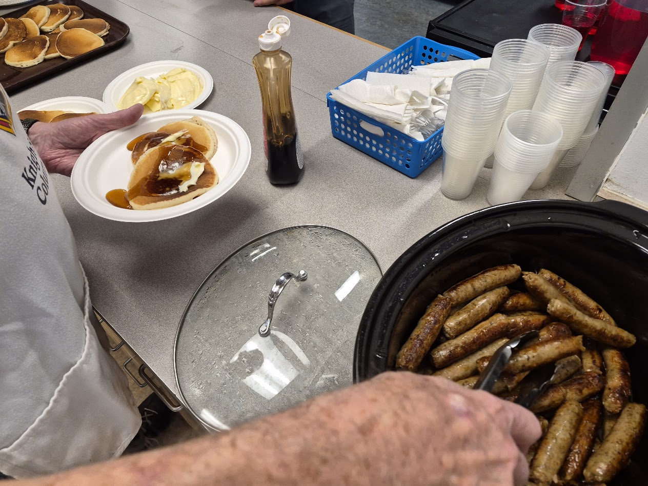 A plate of pancakes and sausages, ready to serve
